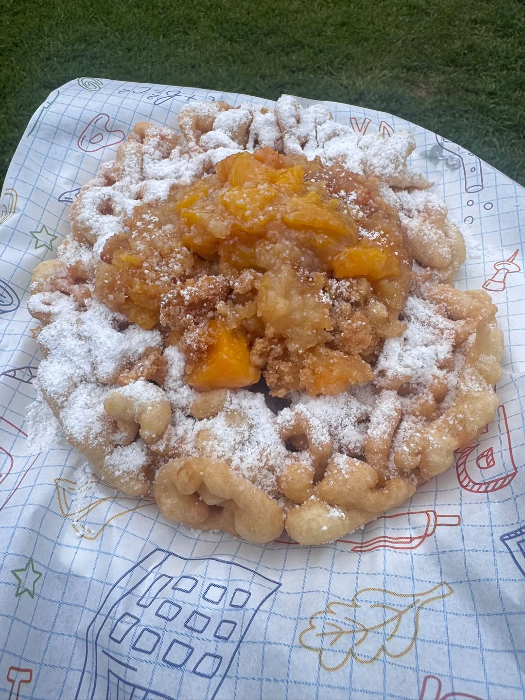 Funnel cake with peach topping and powdered sugar, shared by Make It SnowCone